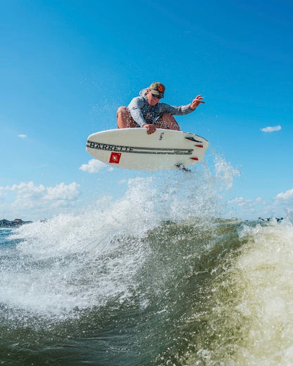 Fat Daddy's Wake Surf Barrette Noah flegel Pro NF1 white wakesurf board performing an aerial trick on a wave