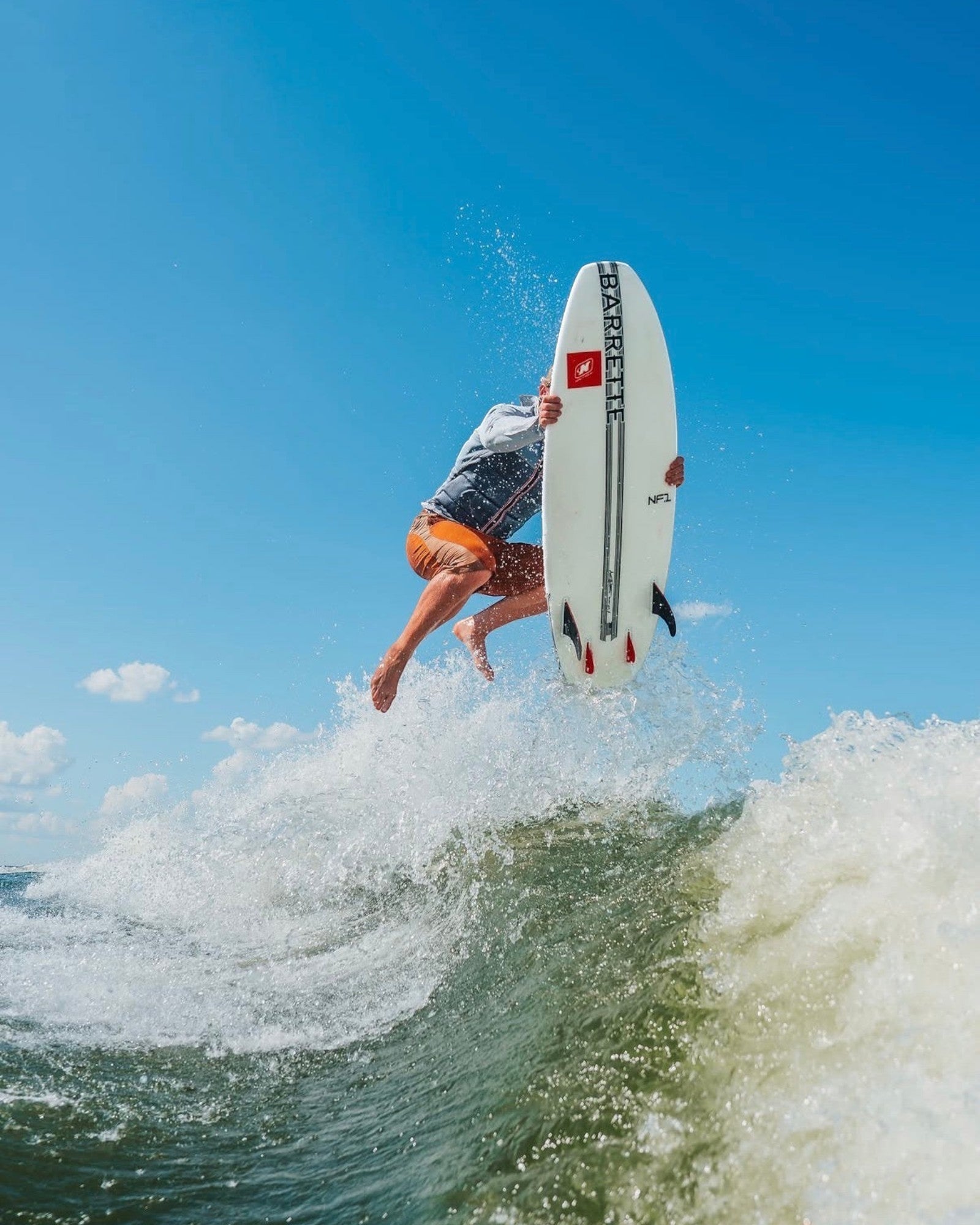 Fat Daddy's Wake Surf Noah Flegel Pro NF1 white wakesurf board being used for an aerial trick on a sunny day