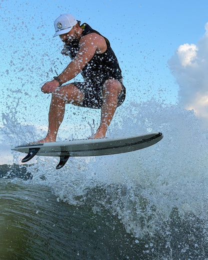 Fat Daddy's Wake Surf white waterproof 5-panel rope hat worn by a man wake surfing on a wave